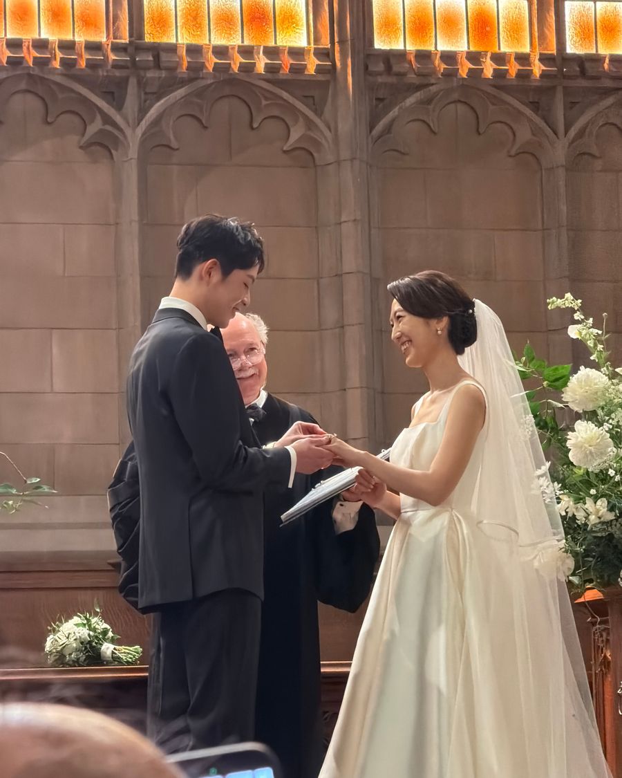Bride and groom exchanging rings at the altar