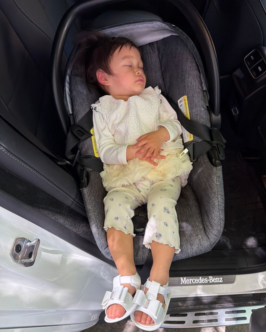 A toddler asleep in a car seat after the wedding